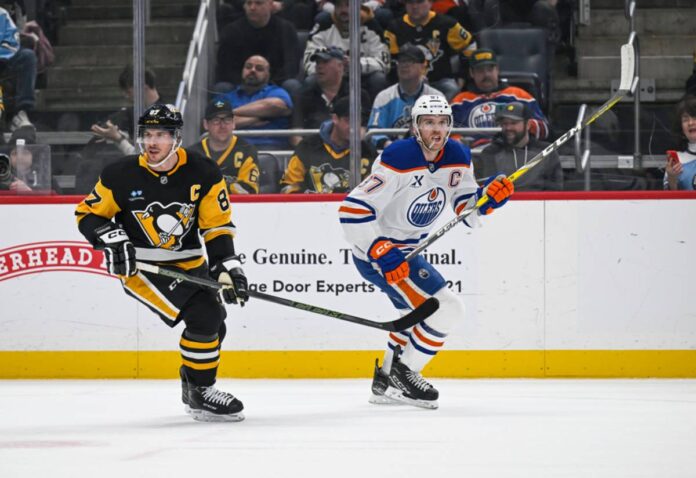Pittsburgh Penguins center Sidney Crosby (87) and Edmonton Oilers center Connor McDavid (97) skate during the first period in the NHL game between the Pittsburgh Penguins and the Edmonton Oilers on January 9, 2025, at PPG Paints Arena in Pittsburgh, PA Sidney Crosby Pittsburgh Penguins captain skating with the puck at PPG Paints Arena