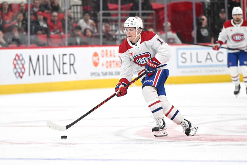 Cole Caufield carries the puck in a white Montreal Canadiens road jersey