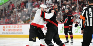 Brady Tkachuk and Jordan Staal fight after the opening faceoff of Game 1