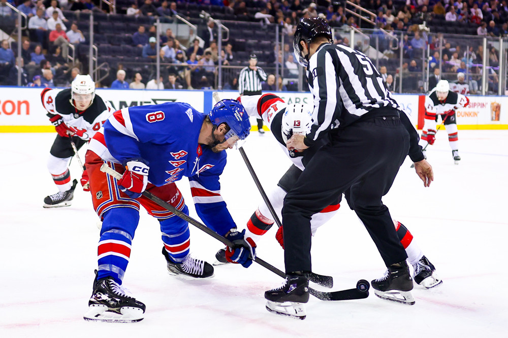 Nico Hischier of the New Jersey Devils battles for a face-off at Madison Square Garden
