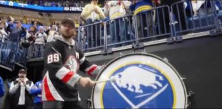 Josh Allen bangs the Lets Go Buffalo drum wearing an Alex Tuch Sabres jersey