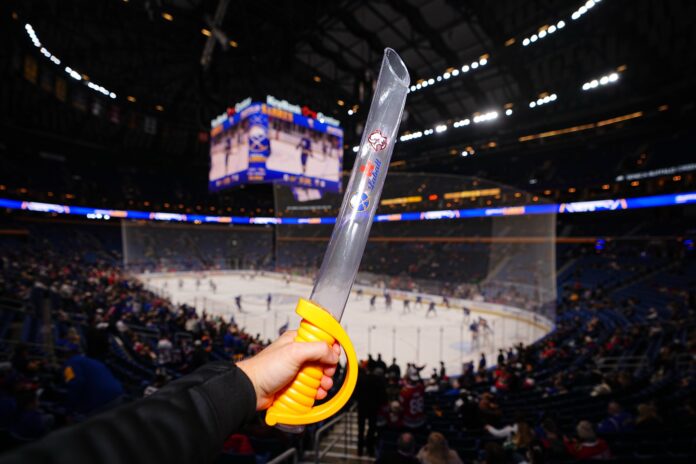 Beer Sabre held up inside KeyBank Center before Sabres Game 7 vs Canadiens 2026 Buffalo Sabres beer sabre Labatt 20-ounce plastic sword KeyBank Center Game 7 Canadiens 2026 Stanley Cup Playoffs