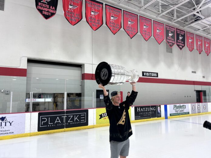 Jackson Blake Stanley Cup day Eden Prairie 2026 Jackson Blake hoists the Stanley Cup at Eden Prairie Community Center under the Eagles state championship banners