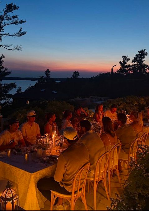 Edmonton Oilers players and partners at a waterfront sunset dinner