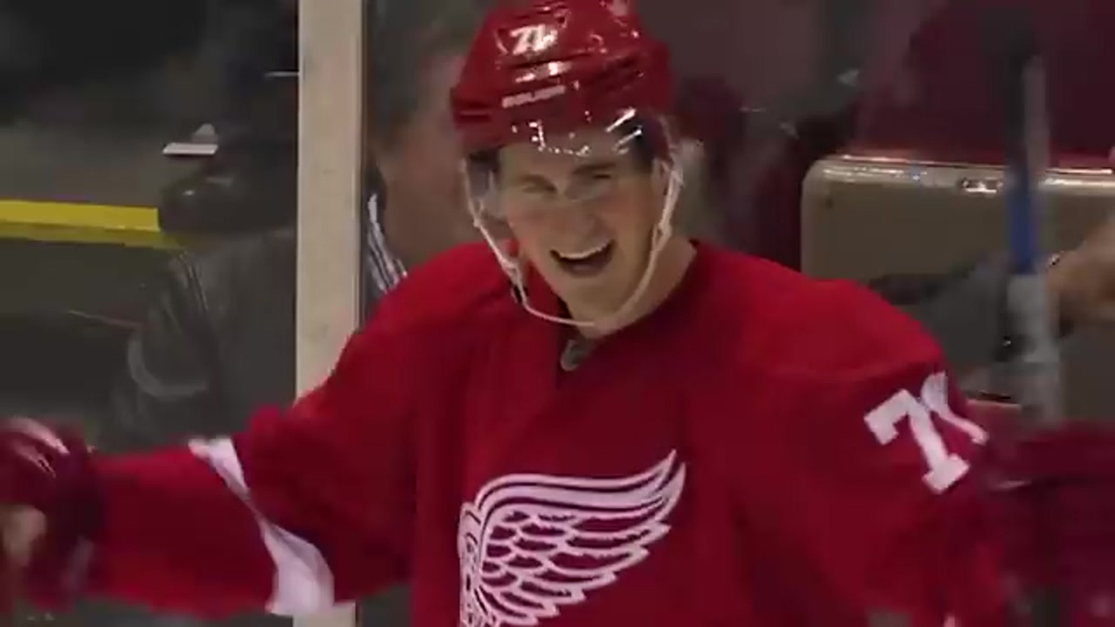 Dylan Larkin celebrates at the Detroit Red Wings bench in the red home jersey, number 71