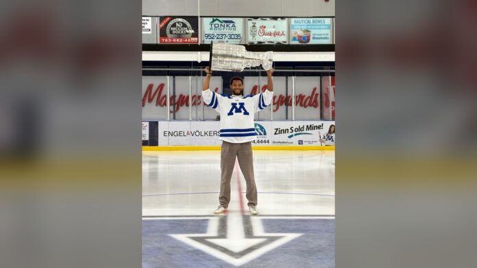 K'Andre Miller Stanley Cup day Minnetonka 2026 Carolina Hurricanes defenseman K'Andre Miller hoists the Stanley Cup at center ice in a Minnetonka High School jersey during his 2026 Stanley Cup day in Minnesota