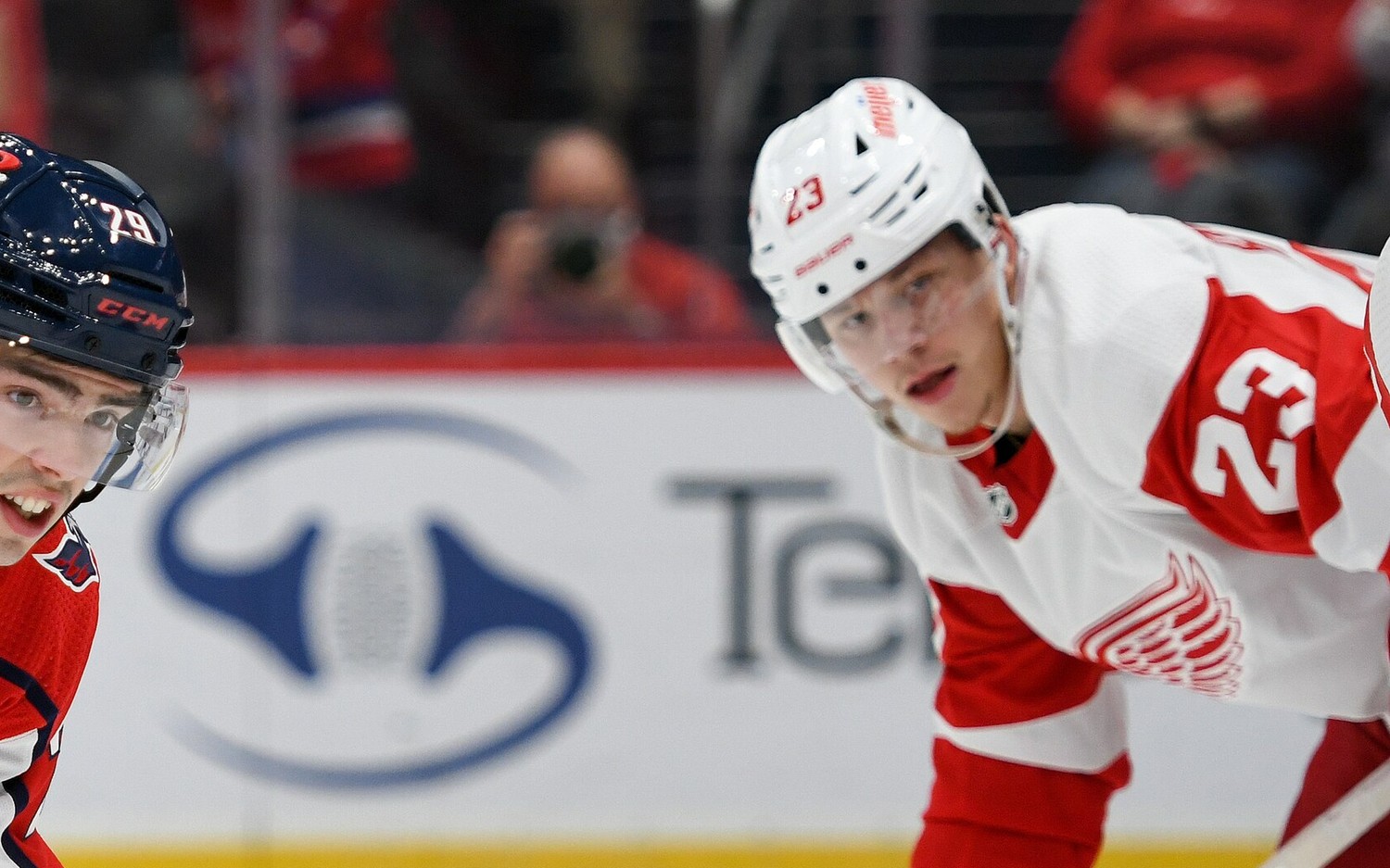Lucas Raymond lines up for a faceoff in the white Detroit Red Wings road sweater