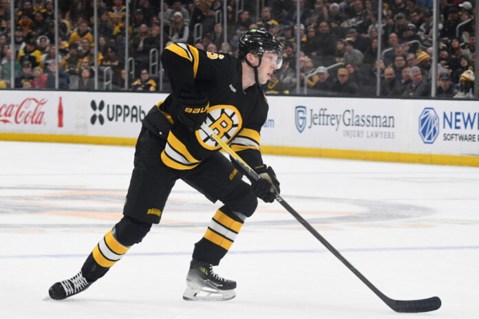 Mason Lohrei Bruins 2026 Mason Lohrei Boston Bruins defenseman skates with the puck at TD Garden during the 2025-26 NHL season
