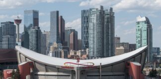Scotiabank Saddledome exterior with the Calgary skyline behind it as the Flames begin their Dome farewell season