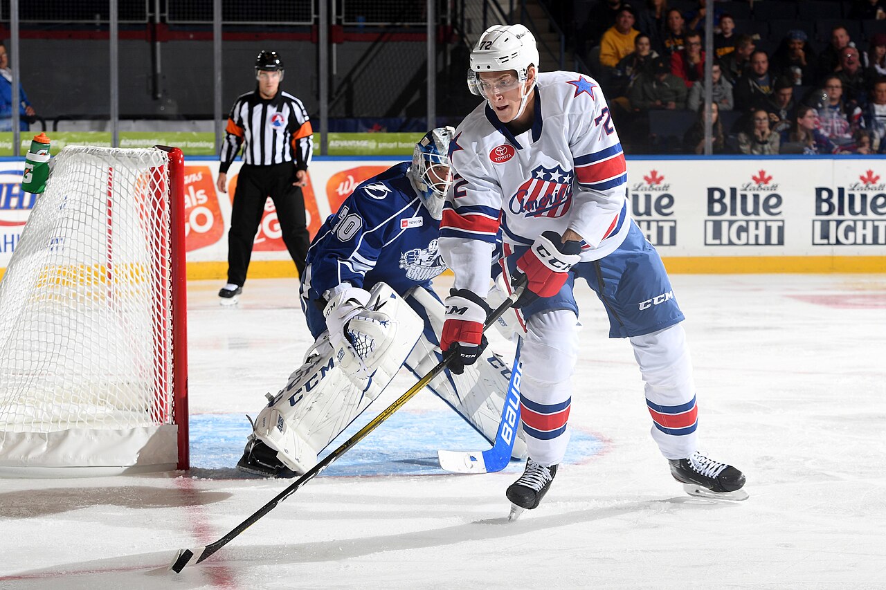 Tage Thompson carries the puck behind the net for the Rochester Americans against the Syracuse Crunch