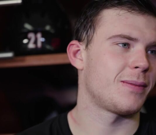 Carolina Hurricanes defenseman Alexander Nikishin speaks to reporters in the locker room