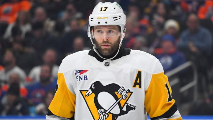 bryan-rust-penguins-injury-2026 Bryan Rust in Pittsburgh Penguins white road jersey wearing the A