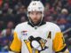Bryan Rust Injury: Penguins Winger Exits Preseason Finale Bryan Rust in Pittsburgh Penguins white road jersey wearing the A