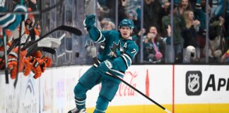 Macklin Celebrini celebrates a goal for the San Jose Sharks in the teal home jersey