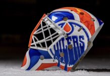 Devon Levi Injured Reserve: Oilers Recall Matt Tomkins Side view of Devon Levi's 2026-27 Oilers goalie mask with dripping OILERS wordmark