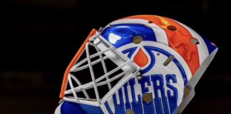 Devon Levi Injured Reserve: Oilers Recall Matt Tomkins Side view of Devon Levi's 2026-27 Oilers goalie mask with dripping OILERS wordmark
