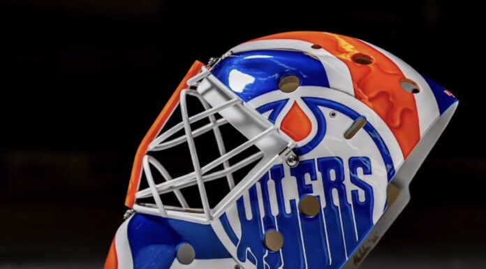 Devon Levi Injured Reserve: Oilers Recall Matt Tomkins Side view of Devon Levi's 2026-27 Oilers goalie mask with dripping OILERS wordmark