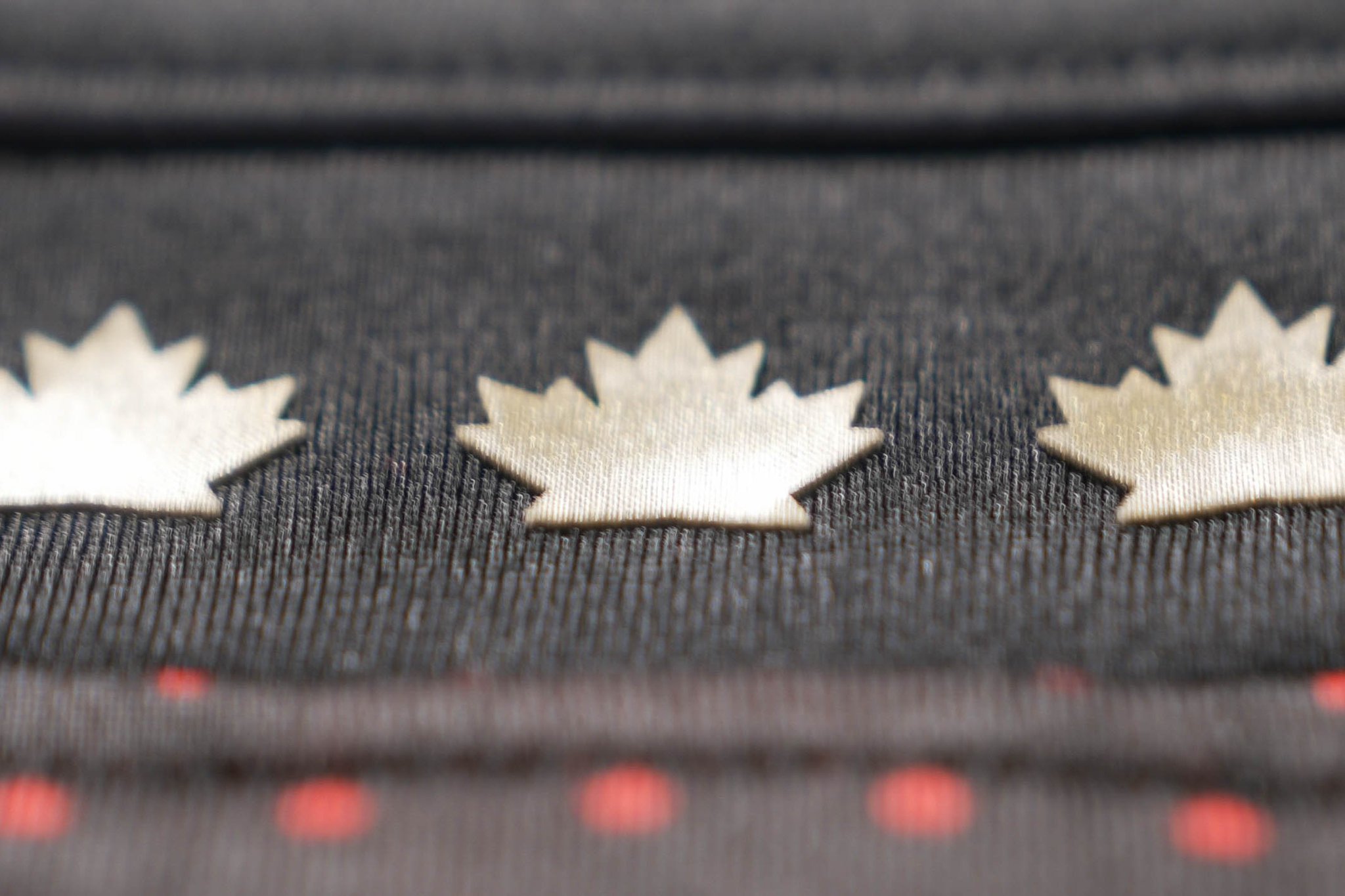 Hockey Canada new jersey teaser with metallic gold maple leaves on a black base