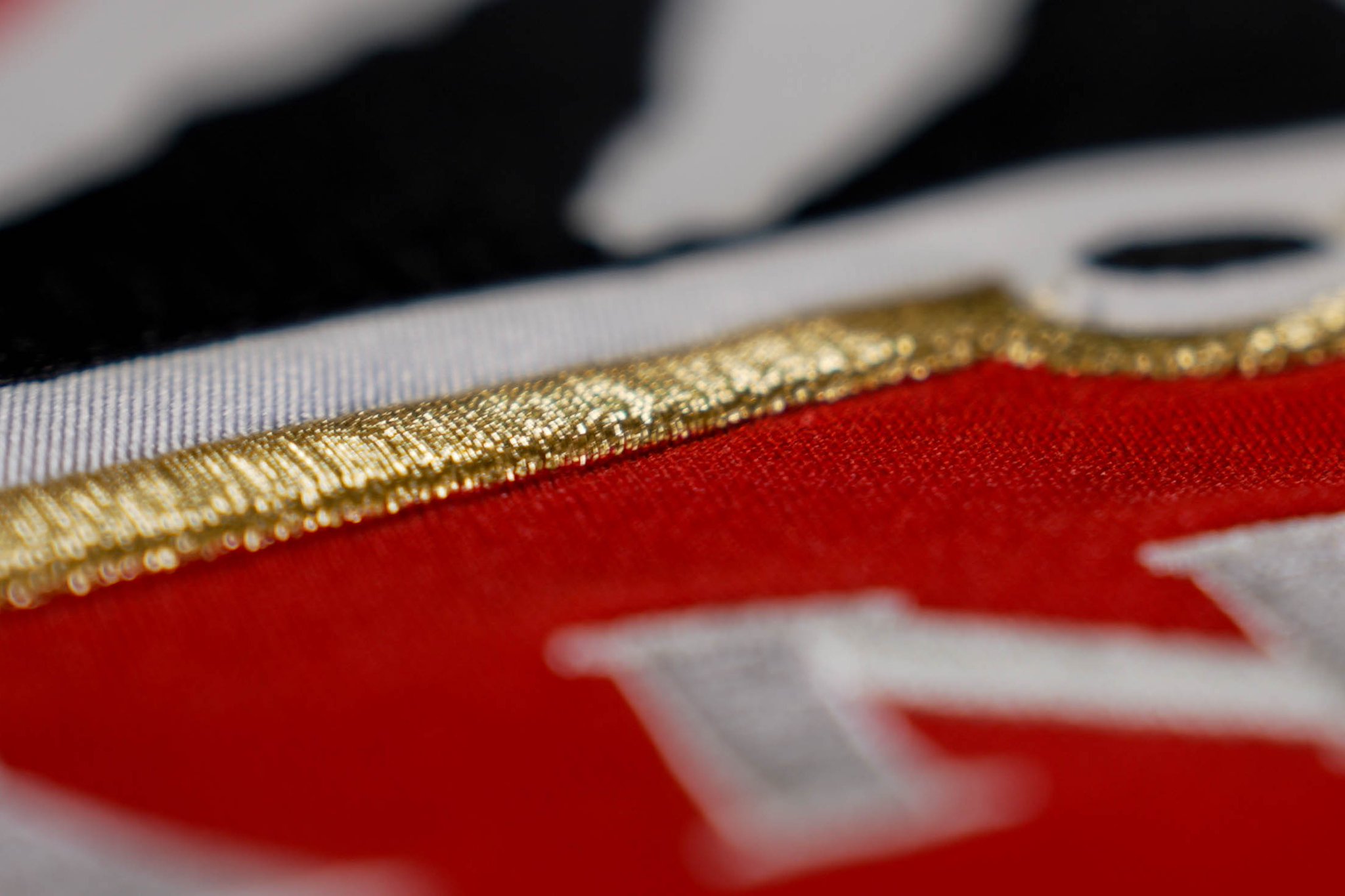 Hockey Canada new jersey teaser showing gold trim and white lettering on a red crest