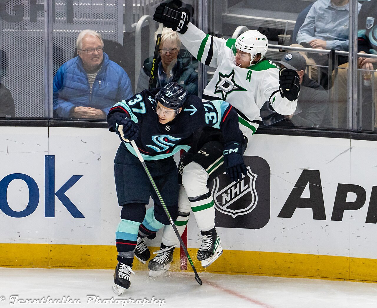 Dallas Stars defenseman Miro Heiskanen pinned along the boards by Seattle Kraken forward Yanni Gourde