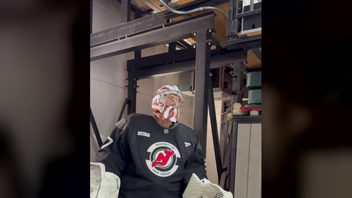Connor Hellebuyck Devils practice Connor Hellebuyck in Devils practice jersey and goalie mask stepping onto the ice in New Jersey