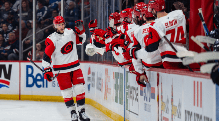 Hurricanes forward celebrates goal at the bench during win over Jets in Winnipeg