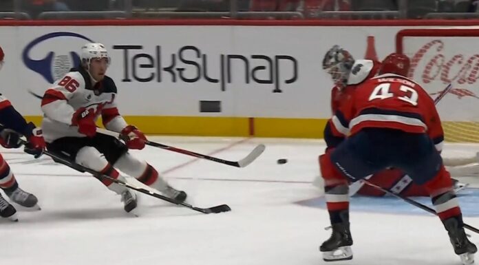 Tom Wilson Hit: Jack Hughes Bails Out Before Contact Jack Hughes Devils shoots backhand as Tom Wilson Capitals closes in during Devils-Capitals game